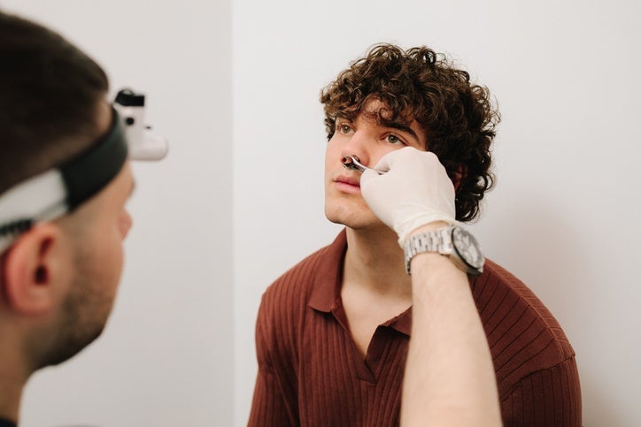 ENT specialist examining a young man's nose for sinus surgery in Surprise, AZ
