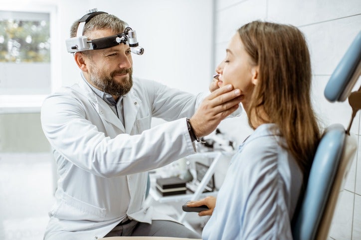 ENT doctor examining a young woman for snoring treatment in Surprise, AZ