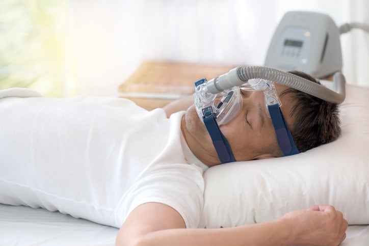 Man sleeping with CPAP mask for sleep apnea treatment in Surprise, AZ
