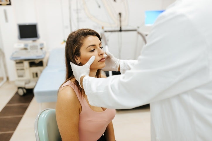 Doctor examining a woman’s face for sinus infection in Surprise, AZ